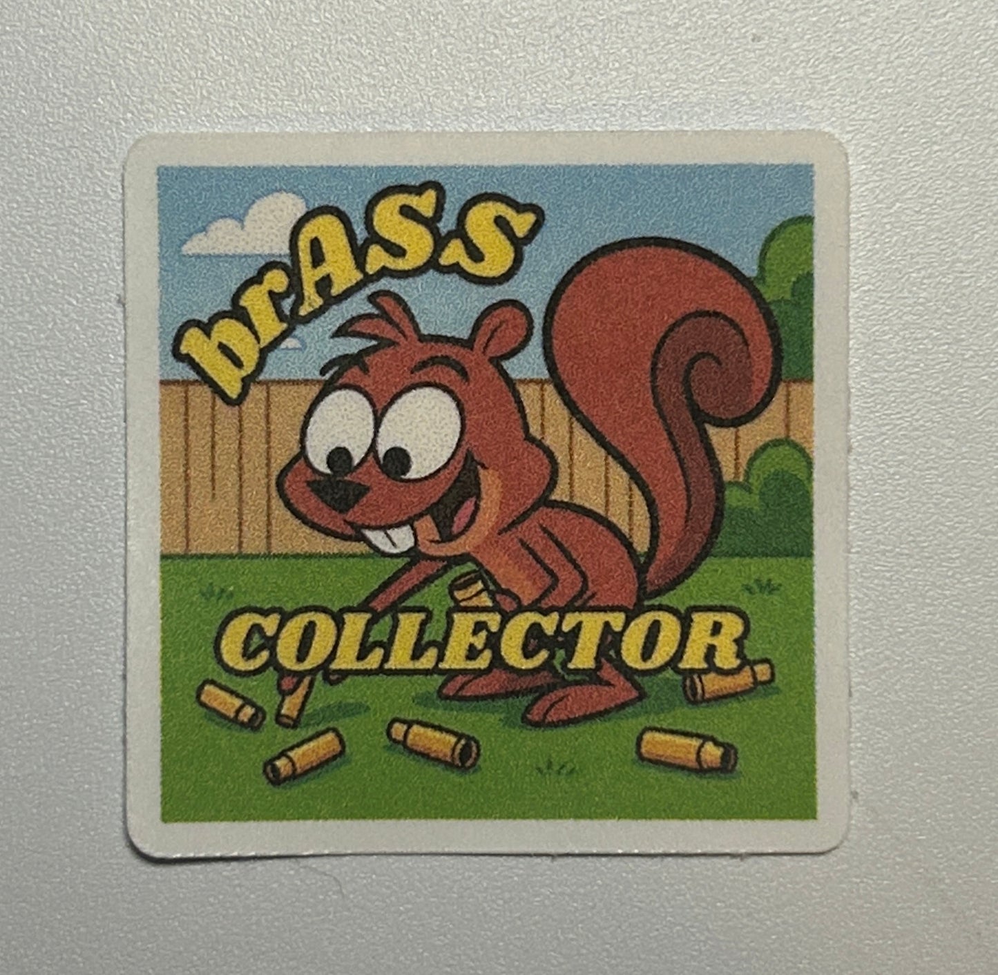 Square sticker featuring a cartoon-style squirrel illustration with text and small illustrated objects on a colorful background.