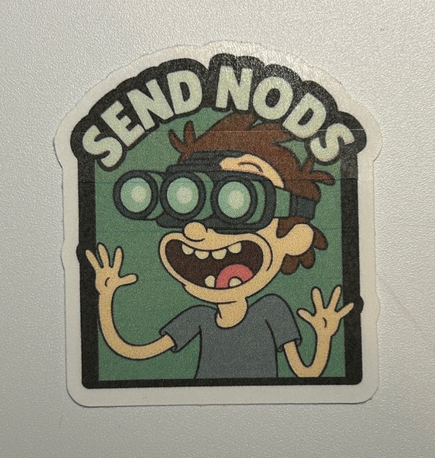 Sticker featuring a cartoon character wearing goggles with raised hands and bold text above the illustration.